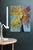 This artwork depicts a vibrant tree in full autumn splendor, its branches adorned with a mosaic of golden leaves against a...