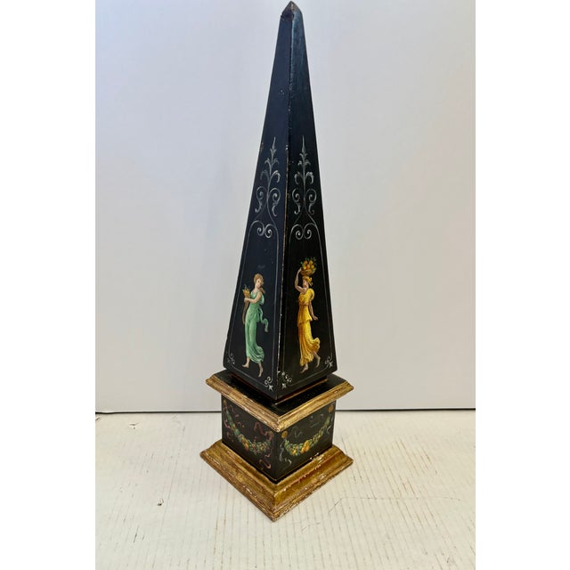 Italian Grand Tour - style obelisk, crafted from lacquered wood with hand painted neoclassical figural motifs.