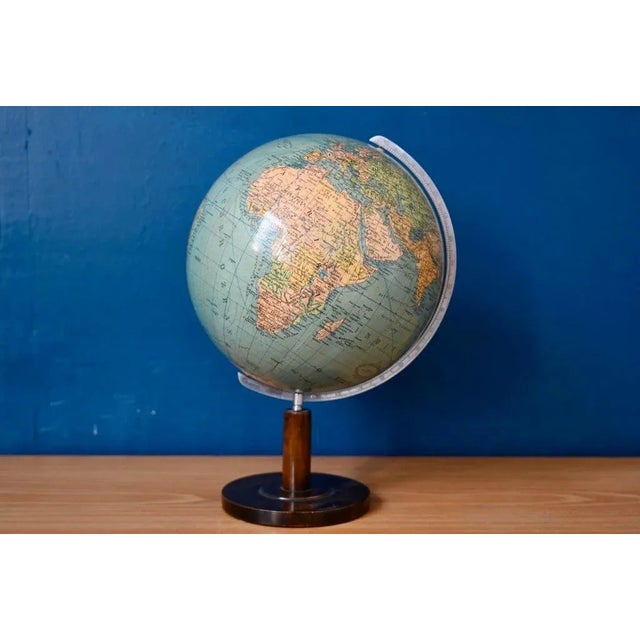 Here's a beautiful invitation to travel, through space and time. This charming globe is supported by a thin wooden stand....