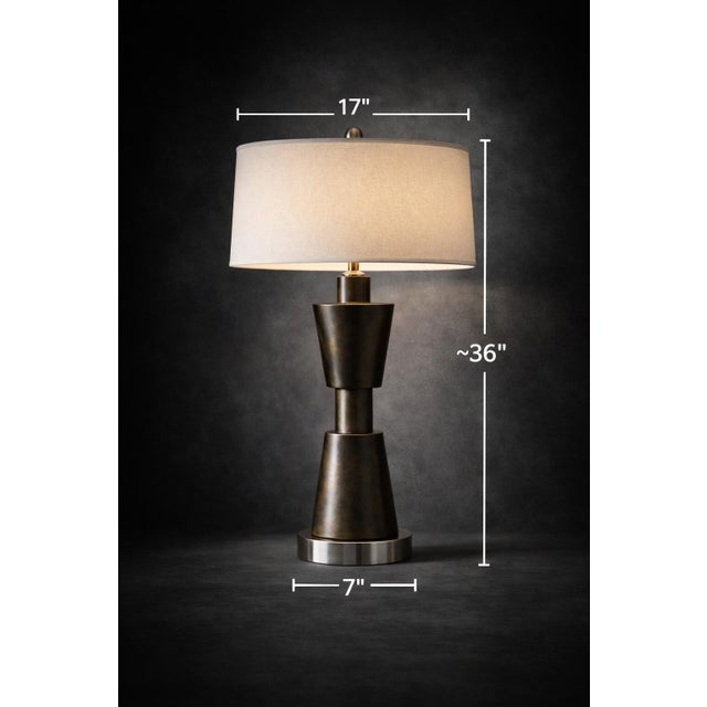 Mobile-Ready Blurb A striking architectural table lamp defined by bold brutalist geometry and a rich aged bronze finish....