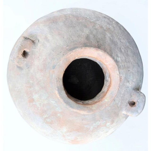 This ancient earthenware storage jar showcases historical hand-coiled craftsmanship with a utilitarian, rustic design. Google