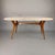 Elegant table from the 1950s. Beech wood frame with an oval marble top featuring gray veining and light pink highlights....
