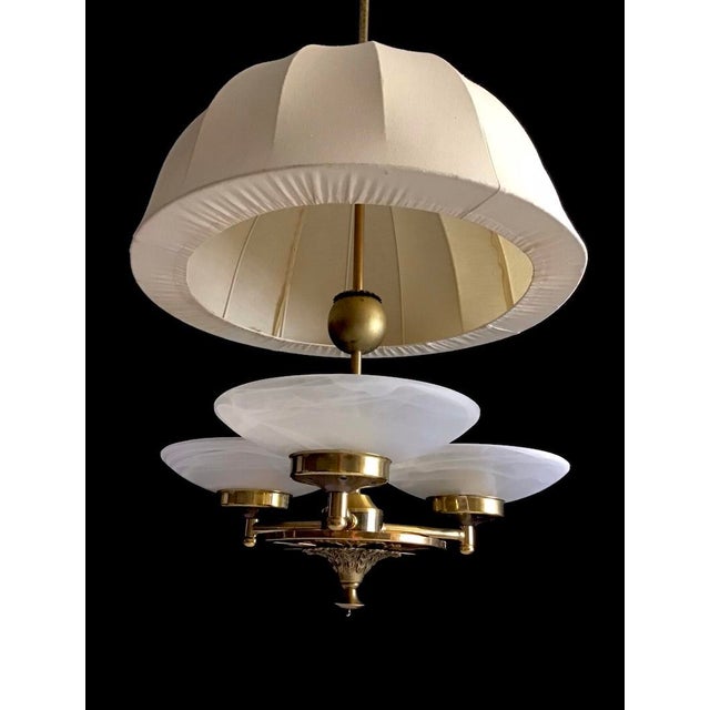 Unique and elegant Swedish modern ceiling lamp in Brass, which combines a classic fixture linen fabric shade, with a...