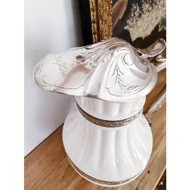 A rare antique circa early 1900s off-white glazed china teapot with silver plated lid and frame, from the Ritz Hotel in...