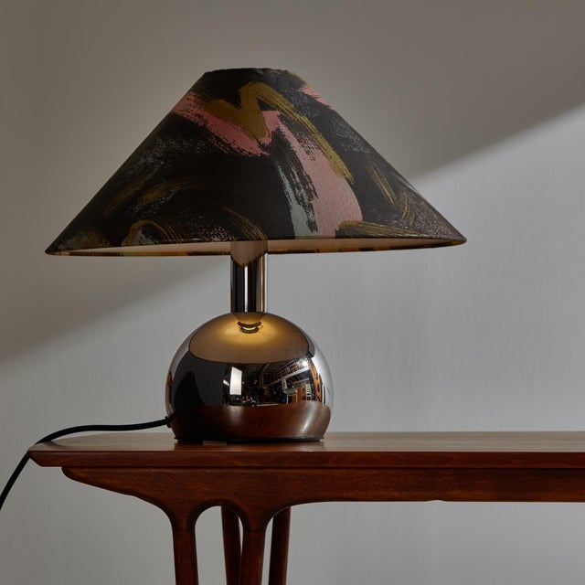 A Rogo Leuchten table lamp from the 1980s with a reflective chrome plated body and a colorful textile lampshade. Surface...