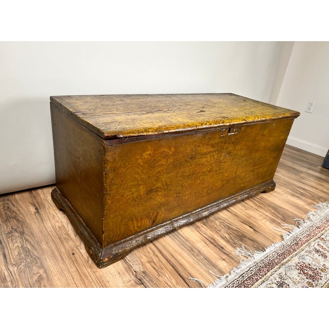 A charming 18th century New England six-board pine blanket box retaining its original or very early mustard grain-painted...