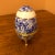 Fine porcelain egg form jewelry trinket box on three gold gilt feet. French milgrain band with floral clasp. Blue and...