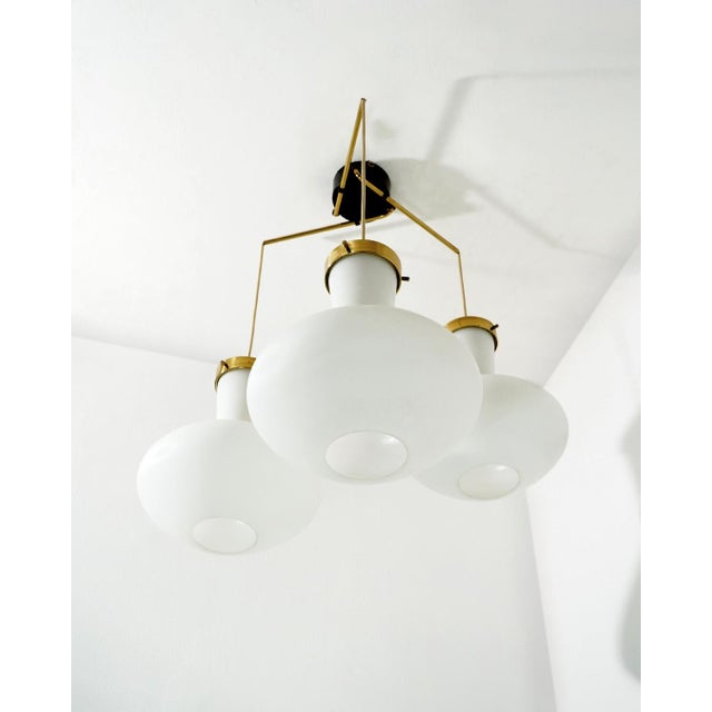 Designed by Stilnovo in the 1950s, this three-light pendant exemplifies the refined balance of geometry and materiality...