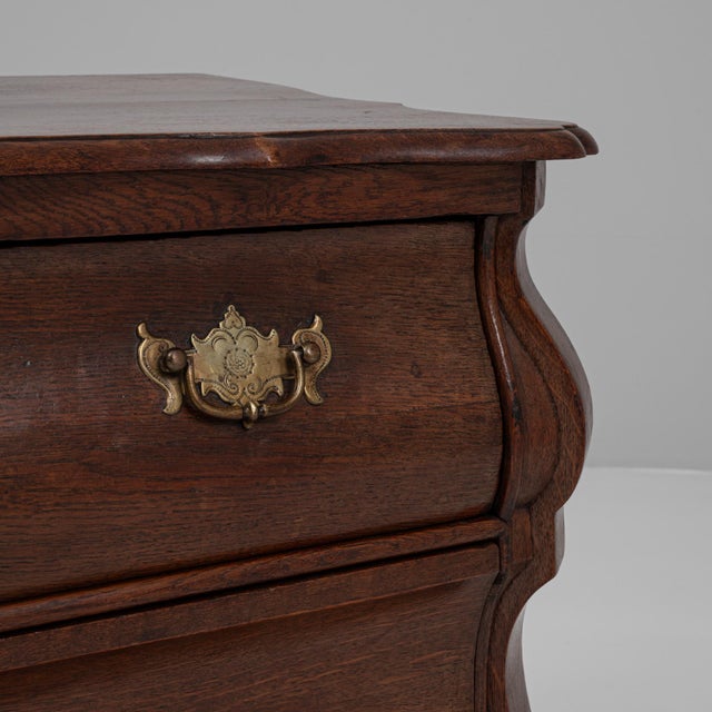 This 1820s Dutch Baroque bombe chest of drawers is a masterful example of early 19th-century craftsmanship, showcasing the...