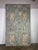 Pair of tall, rustic double doors with an ornate and distressed finish. The doors are painted in a faded greenish-blue...