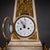 Obelisk-shaped marble clock with fire-gilt bronze appliqués, relief scene, and a surmounting armillary sphere. The clock...
