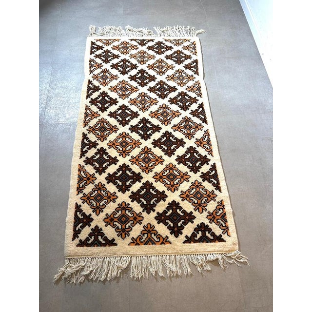 Authentic vintage hand-knotted rug originating from Tunisia, crafted from natural wool. This piece features a rhythmic...