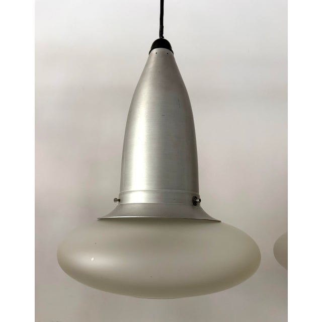 Here is a pair of sculptural Space Age pendant lights dating to the 1960s. Each features an elongated brushed aluminum...