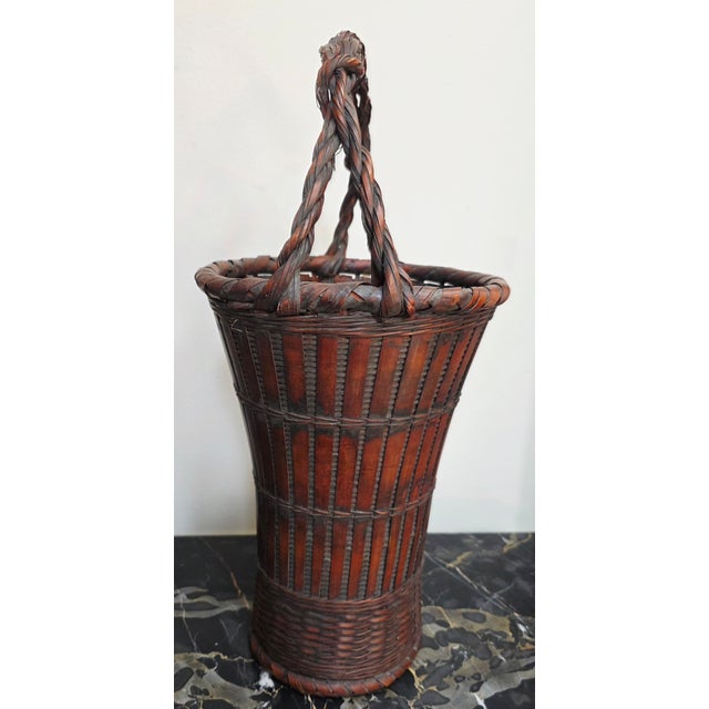 This early 1900s Meiji Japanese bamboo basket with a root handle is a beautifully crafted piece perfect for use in an...