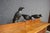 Set of three carved wooden crow decoys, each featuring a black painted finish, glass eyes, and metal legs. The figures...