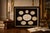 refined collection of Grand Tour–style plaster intaglios, beautifully arranged in a shadow box frame against a rich dark...