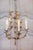 A French gilt metal five-light chandelier from the 20th century inspired by Maison Charles. This elegant French gilt metal...