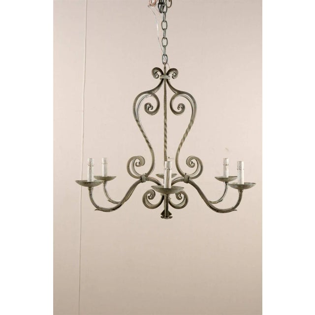 A French painted iron six-light chandelier. This French vintage mid-20th century light fixture is made of a succession of...