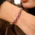 This statement tennis bracelet features oval cut natural rubies totaling 12.57 carats, set in solid 14K yellow gold....