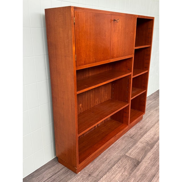 Italian-made bookcase produced in the 1960s. Made of teak veneer. Comprising shelves and a compartment closed by two small...