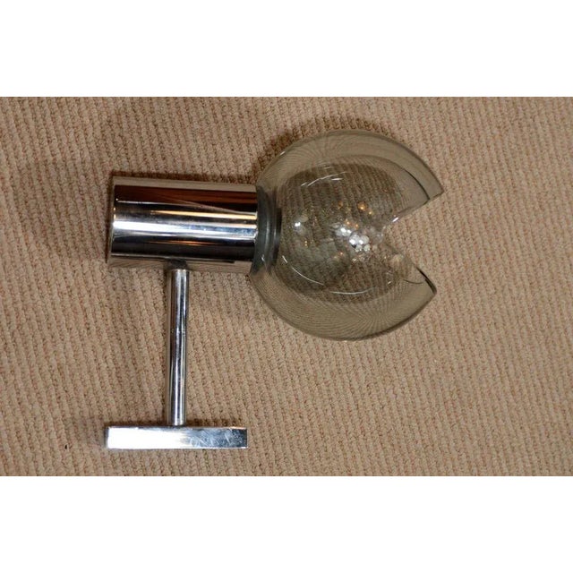 A lovely pair of grey glass globe and chrome sconces produced by Seguso in the 1960s. Each globe is handblown with a pie...