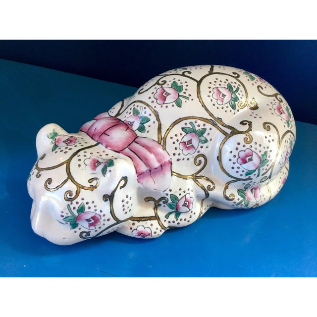 Lovely ceramic cat covered in details. Had painted flowers and gold swirls topped with a pink bow adorn this beautiful piece.