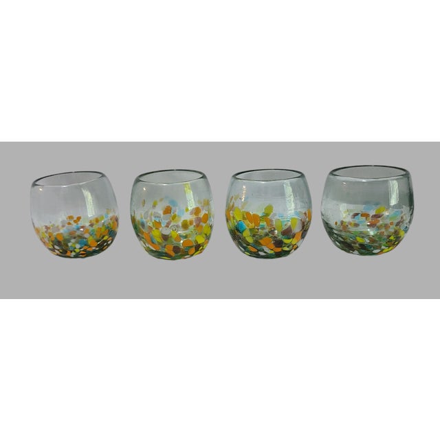 Add some sparkle to your drinkware collection with this set of four colorful confetti hand blown art glass lowball...