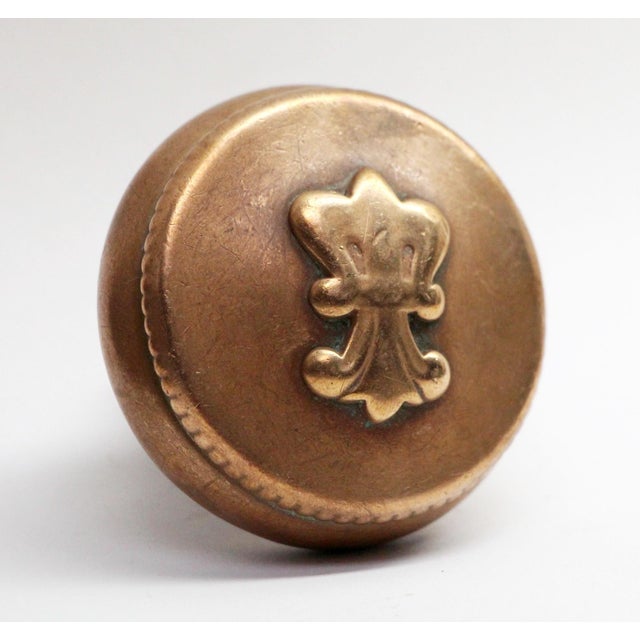 Antique fleur de lis Reading brass two fold door knob. It is part of the F-21410 Verdun group. The manufacturer is...