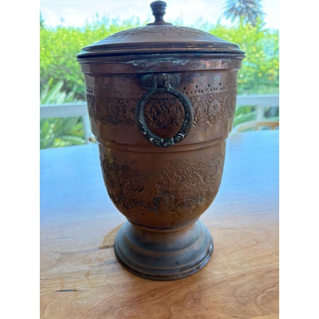 Hand-chased copper ice bucket with matching lid. Detailed middle eastern motif with camels and palm trees. Includes an...