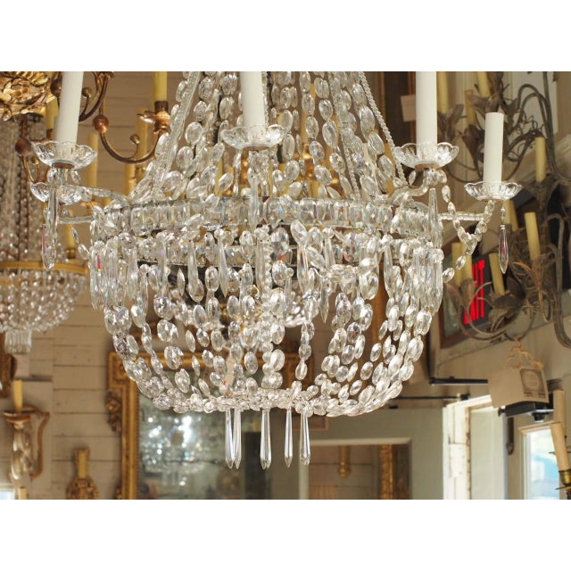 Early 19th century 3 tiers French crystal chandelier. Crystal bobeches. Iron arms are crystal beaded. The center shaft is...