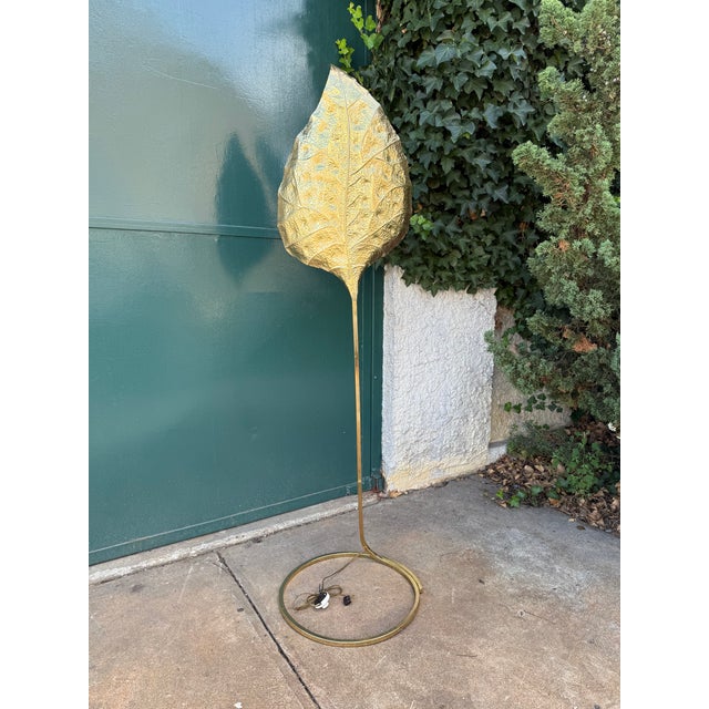 Tall brass standing lamp with a hammer leaf motif shade attributed to Tommaso Barbi for Bottega Gadda, Italy. The lamp is...