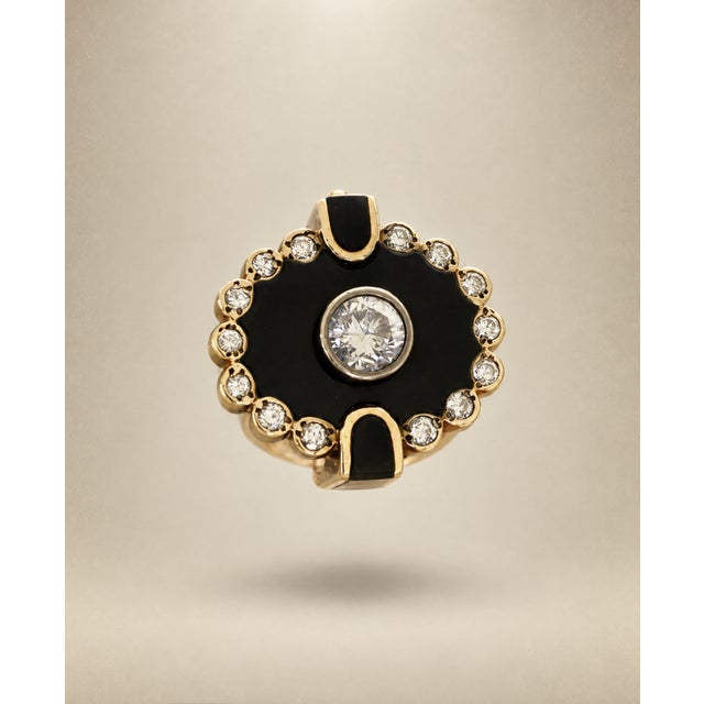 14k yellow gold ring is finished with a hinged shank. The ring is centered with one, bezel set, round, brilliant cut...