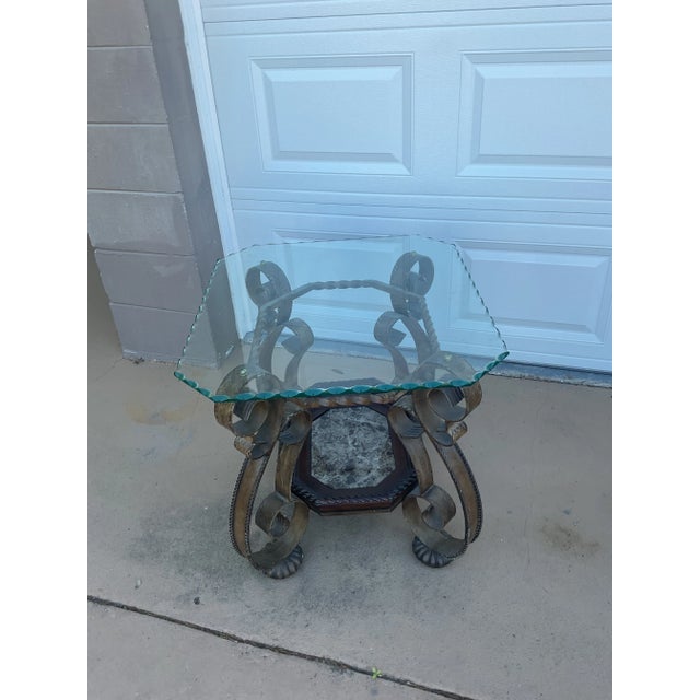 Striking architectural pair side tables featuring an ornate hand-forged style iron base with dramatic scrollwork and a...