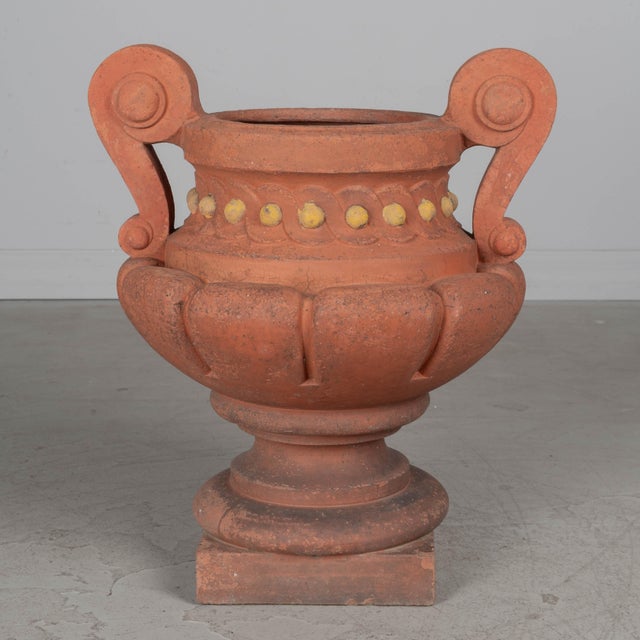 A late 19th century French terracotta garden urn, or planter. Bold form with large thick handles and yellow painted bead...