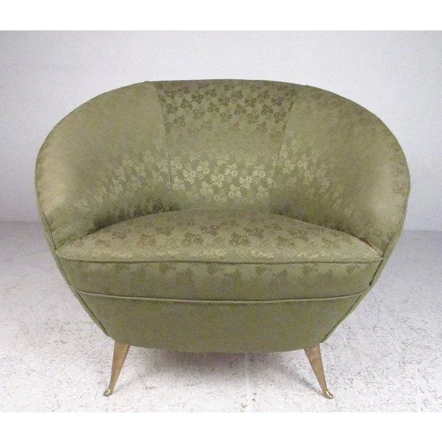 This vintage pair of Italian modern lounge chairs features elegant sculpted seats with stylish vintage upholstery. The...