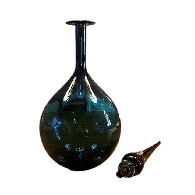 The Joe Cariati Large Tear Drop Decanter in Steel Blue is a hand‑blown glass statement piece defined by its tall,...