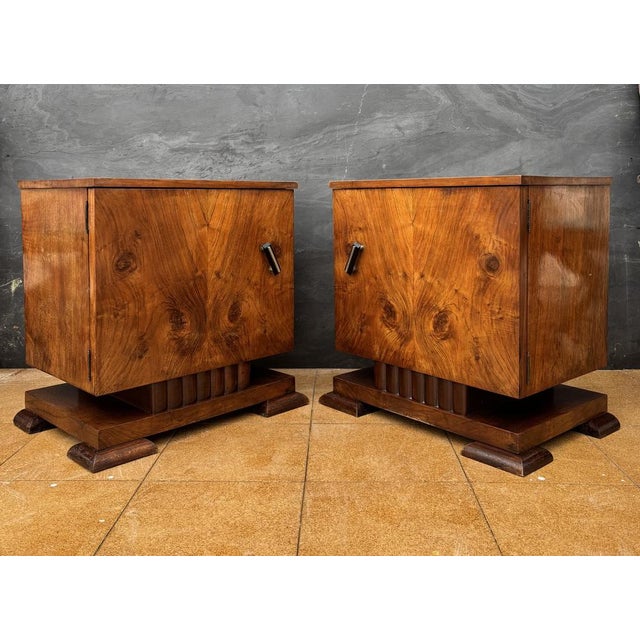 Elegant pair of Art Deco nightstands dating to the 1940s. Each nightstand features a clean cubic form enhanced by...