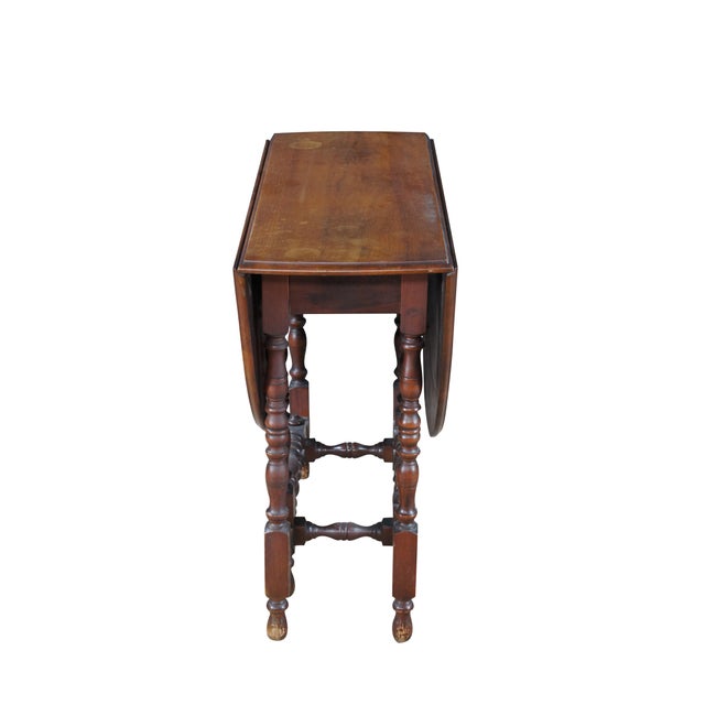Early 20th Century William & Mary style gateleg table. Features an oval form over turned legs with peg feet. When not in...