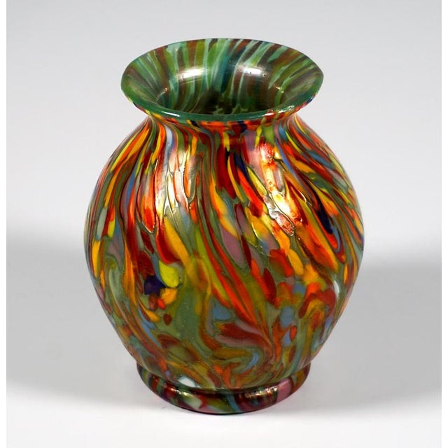 Mould-blown, bulbous body on a ring base, with a flared rim created by a constriction at the neck; colourless glass with a...