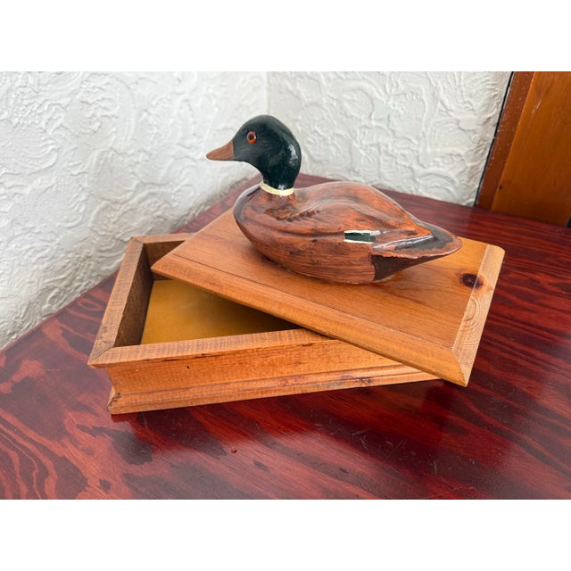 Wooden pine box topped with a hand-painted mallard drake. The duck has glass eyes, a glossy green head, and a crisp white...