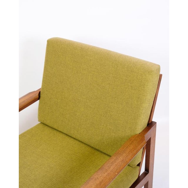 Capella armchair made of teak with cushions upholstered in green fabric. Designed by Illum Wikkelsø and manufactured by...