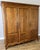 An elegant Vintage French Louis wardrobe in Oak, featuring three tall panelled doors, a warm finish with prominent grain,...