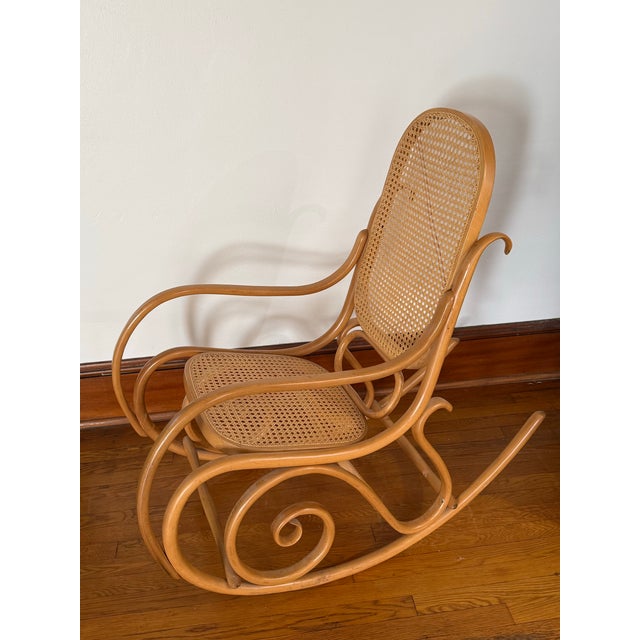 This vintage rocking chair is made of steam bent wood in a light natural finish, with scrolls along each side. The seat...