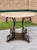 A striking neoclassical style dining table or center / foyer table in hand-worked solid steel with four scroll supports,...