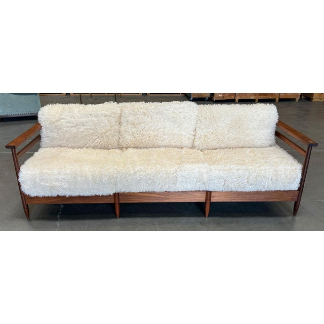 Natural Walnut Finish on Walnut. Smooth, Polished Brass Medallions at Front and Back of Arms. Upholstered in Casamance...