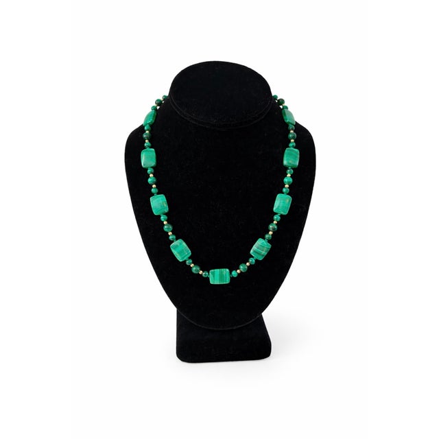 A striking vintage malachite necklace featuring a beautifully balanced arrangement of polished malachite beads and...