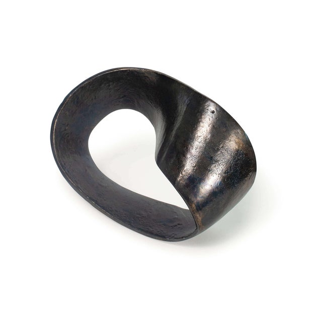 An infinity knot crafted out of aluminum, cast to capture a textured surface this object is an industrial work of art....