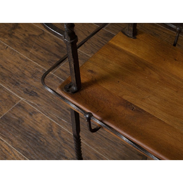 A vintage American Industrial style wood and metal shelving unit from the mid 20th century with two shelves, twisted...