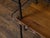 A vintage American Industrial style wood and metal shelving unit from the mid 20th century with two shelves, twisted...