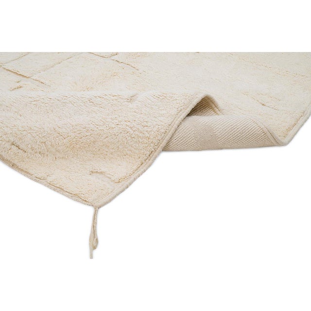 Elegant hand-knotted wool rug in soft Ivory hues, featuring a subtle abstract pattern. Its refined soft texture brings...